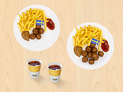 Top-down view of two plates from file 1.jpg on a wooden table, each containing IKEA Swedish meatballs with small Swedish flags, french fries, gravy, and jam, next to two IKEA paper cups.