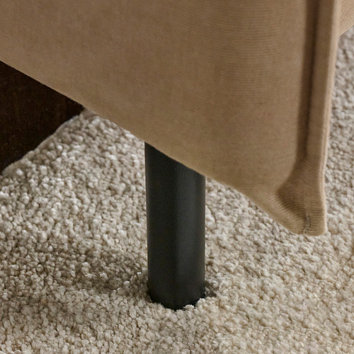 Un sofá moderno con respaldo alto, cojines cómodos y patas metálicas negras y elegantes para un soporte aireado.