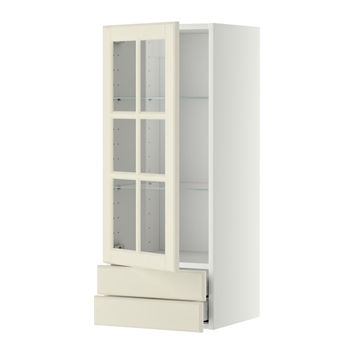 Un mueble de cocina más alto de color blanquecino con puertas y cajón de cristal.