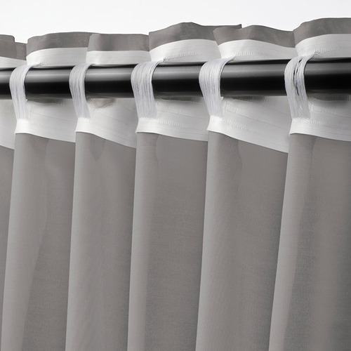 Barra de cortina negra con cortinas blancas transparentes en tonos grises. La cinta de cabecera plisada permite una fácil fijación de la varilla.