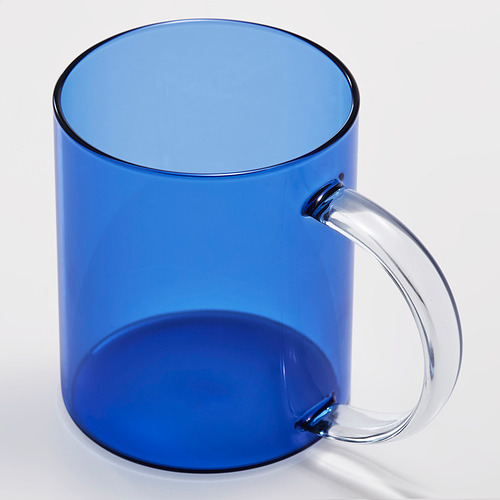 Taza azul opaca con asa curva transparente, borde pulido.