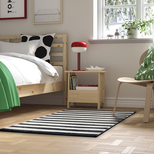 Elegante alfombra en blanco y negro en un dormitorio bien iluminado, equilibrando la decoración con material de poliéster reciclado.