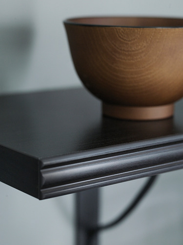 Una estantería de pared BERGSHULT en marrón-negro con diseño de borde biselado.