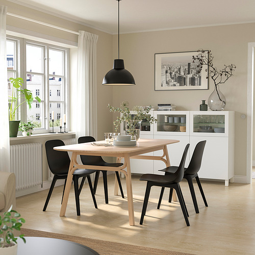 Comedor moderno con mesa VOXLÖV, sillas negras y gran ventanal.