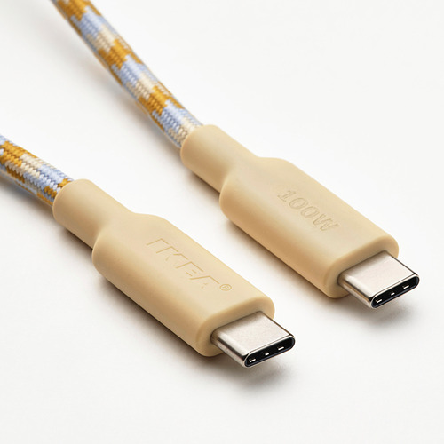 Dos cables usb-c beige con tela tejida azul/amarilla sobre superficie blanca, conectores de la marca.