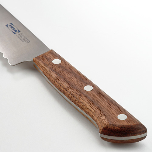 Cuchillo con hoja dentada y mango de nogal oscuro, que muestra una calidad afilada y equilibrada.