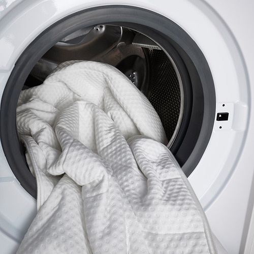 Lavar una colcha blanca y suave en una lavadora de carga frontal.