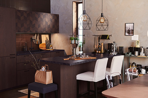 Cocina moderna con gabinetes de madera oscura SINARP, taburetes blancos, lámparas colgantes y accesorios de encimera.