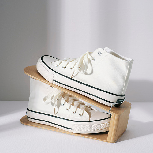 Zapatillas blancas perfectamente apiladas en un zapatero de madera HÖSVANS, ahorrando espacio de manera eficiente.