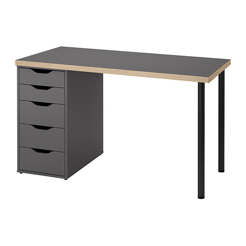 Moderno escritorio gris con cuatro cajones a la izquierda, patas negras, tapa rectangular.