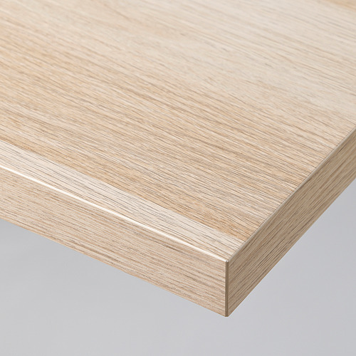 Primer plano de una mesa moderna elegante y de color claro con acabado liso y bordes afilados.