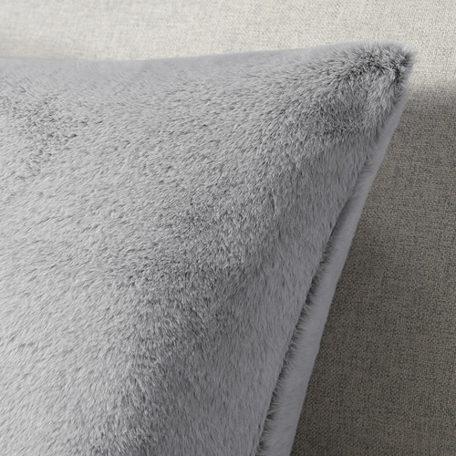 Cojín suave y afelpado gris con textura esponjosa, fabricado en poliéster reciclado, cierre de cremallera.