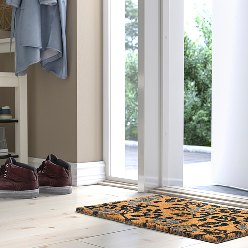 Felpudo PLATSMÄRKE marrón y azul cerca de puerta blanca.