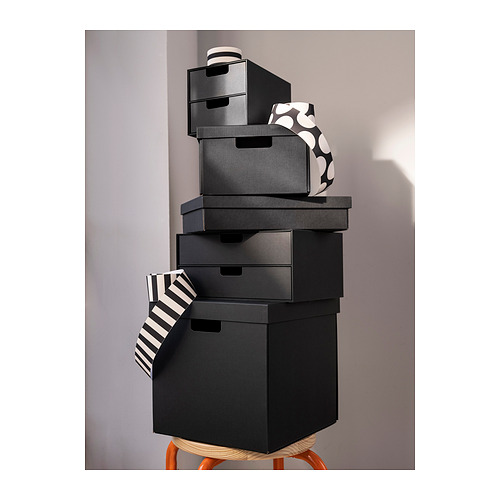 Pila de cajas negras de FJÄDERHARV. La caja superior tiene un diseño estampado.