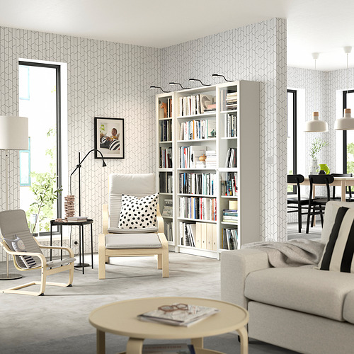 Sala de estar moderna con estantería BILLY en blanco roto, sofá y sillones blancos, mesa de centro de madera y grandes ventanales.