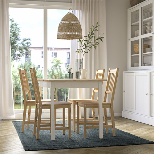 Moderno comedor con alfombra LANDBANA, mesa de madera, lámpara colgante y vitrina.