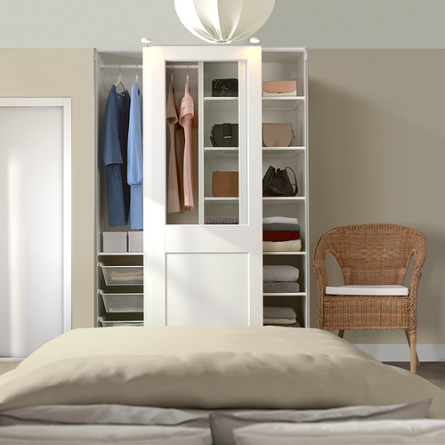 Dormitorio moderno con armario PAX, ropa y silla de mimbre.