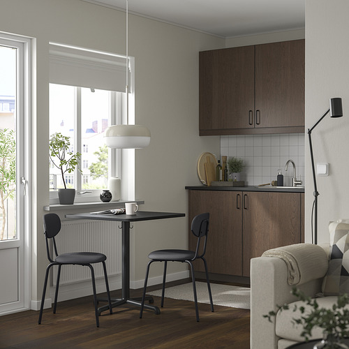 Cocina moderna con mesa STENSELE negra, 2 sillas, lámpara blanca, cerca de la ventana. Diseño compacto y elegante.