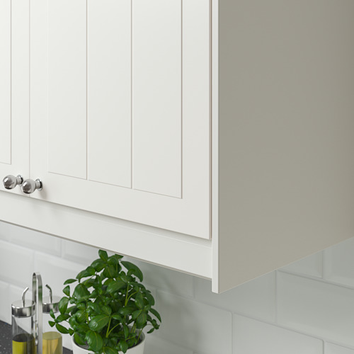 Mueble de cocina blanco con manijas plateadas e iluminación debajo del gabinete, con una planta verde y dispensadores de aceite en la encimera.