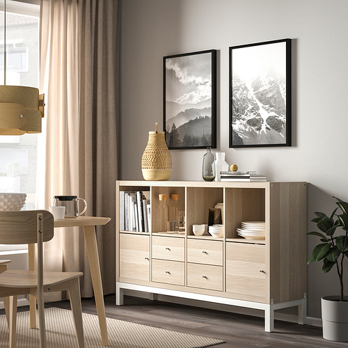 Sala de estar moderna con estante KALLAX, acabado de nido de abeja, cuencos, libros, jarrones, cesta de mimbre, muebles de madera.