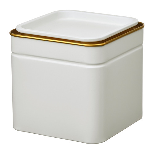 Una lata cuadrada blanca con un borde dorado, sentada en posición vertical.