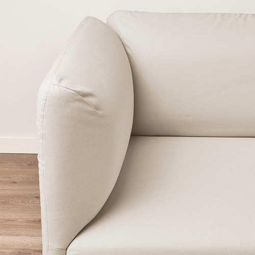 Sofá moderno con elegante tapicería beige, con cojines de felpa y tela lisa, que resaltan la comodidad y el estilo.