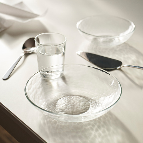 Cuenco de vidrio STRANDKRABBA, transparente y texturizado, con tazón, vaso, cuchara y cuchillo más pequeños.