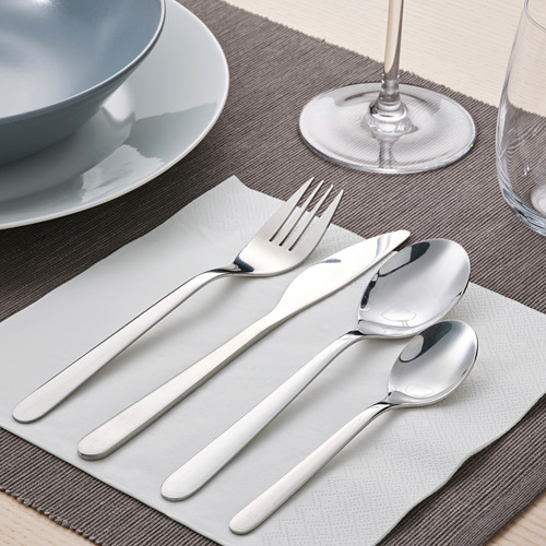 Cubiertos de acero inoxidable sobre una mesa que incluyen tenedor, cuchillo y cucharas, dispuestos cuidadosamente en una servilleta.