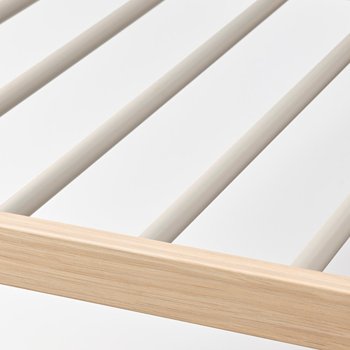 Vista en primer plano de la percha de pantalón moderna con marco de madera suave y clara y elegantes barras de metal.