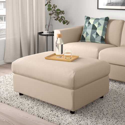 Reposapiés VIMLE beige con almacenaje, sofá a juego, bandeja con bebidas, planta.