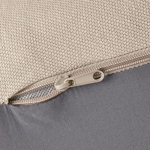 Primer plano de la cremallera en tela beige, que muestra costuras de calidad y material duradero.