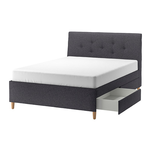 Cama tapizada moderna en color gris con cabecero inclinado, patas de madera y cajones de almacenaje para espacios compactos, serie IDANÄS.