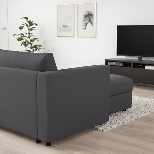 Sala de estar moderna con sofá VIMLE gris en forma de L, tv y planta.