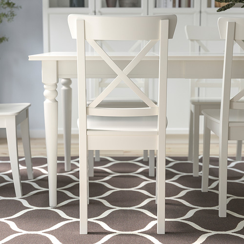 Sillas de madera blanca alrededor de una mesa, adecuadas para comedor o sala de estar, con construcción de madera maciza duradera.