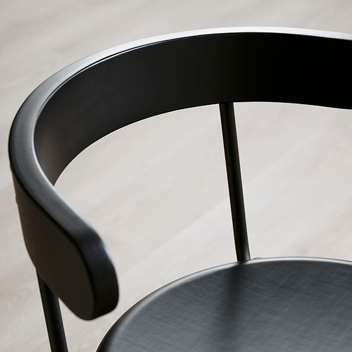 Silla moderna negra con respaldo y reposabrazos redondeados. Diseño elegante y pulido.