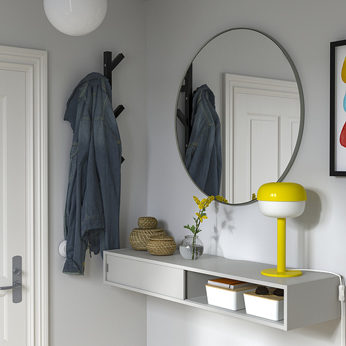 Entrada moderna con pared gris, estante con chaqueta de mezclilla, lámpara, flores, espejo y almacenamiento.