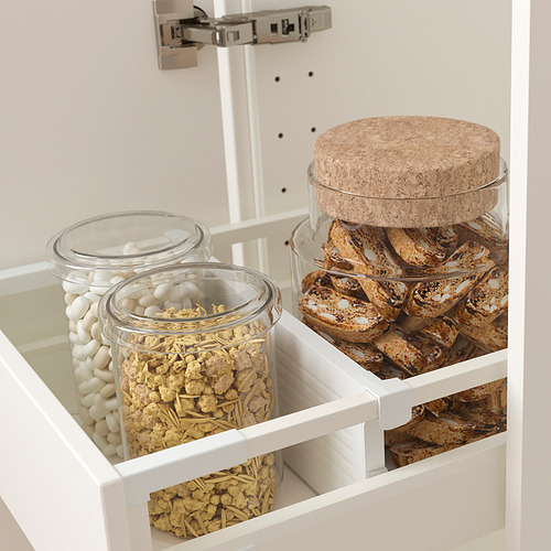 Cajón de cocina abierto con tarros de vidrio para alimentos y divisores ajustables.