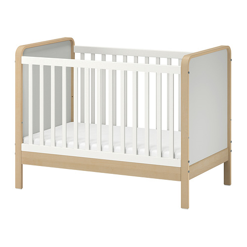 Cuna ÄLSKVÄRD de madera blanca y clara con lateral extraíble, base ajustable y barandilla.