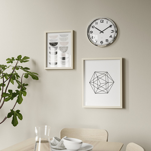 Comedor moderno con reloj redondo, arte y planta.