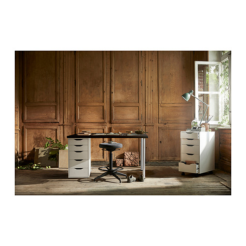 Imagínese una configuración compacta de oficina en casa con un escritorio LAGKAPTEN blanco y cajoneras contra paredes con paneles de madera.