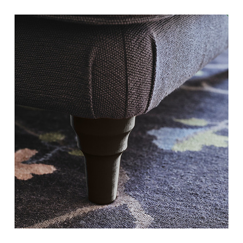 Primer plano de una robusta pata de sofá de madera pulida en un rico acabado marrón, que refleja la artesanía de calidad.