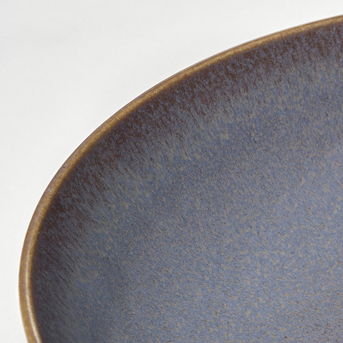 Cuenco vidriado azul, primer plano en blanco.