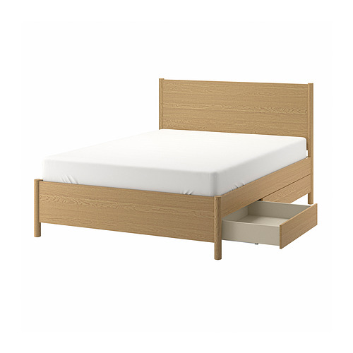 Cama TONSTAD de madera clara con colchón blanco y cajón debajo de la cama.