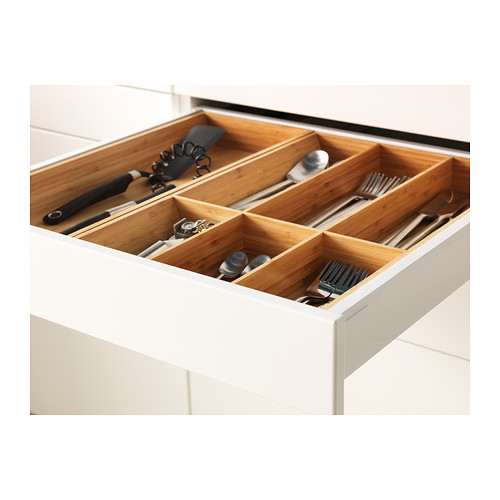 Cajón de cocina abierto con compartimentos de madera para guardar utensilios.