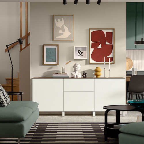 Salón contemporáneo con aparador grande de BESTÅ , arte rojo, sofá verde y alfombra estampada.