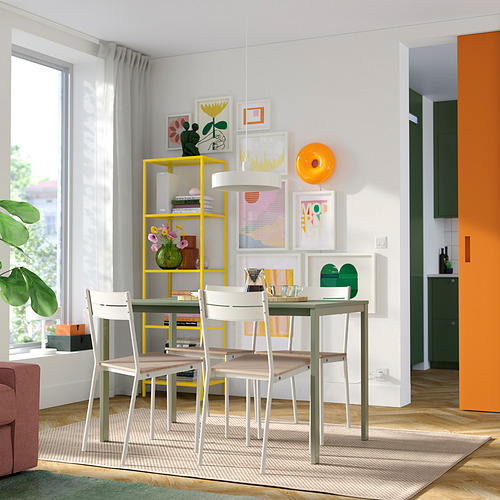 Comedor moderno con sillas BUSLÄTT, estantería amarilla y pared de galería de arte.