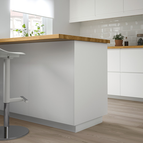 Moderna isla de cocina blanca con encimera de madera. Encaja perfectamente entre taburetes y armarios.