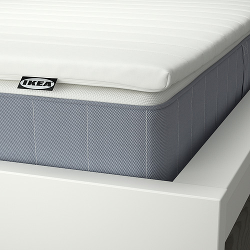 Primer plano del colchón vesteroy de ikea, con la parte superior blanca y la base gris, con la etiqueta de ikea visible.