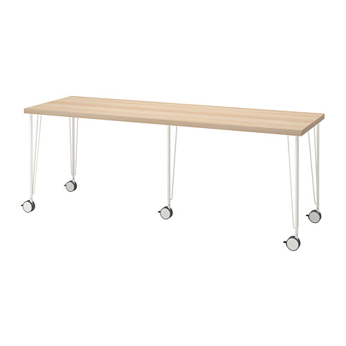 Un escritorio LAGKAPTEN de madera clara con patas y ruedas de metal blanco.