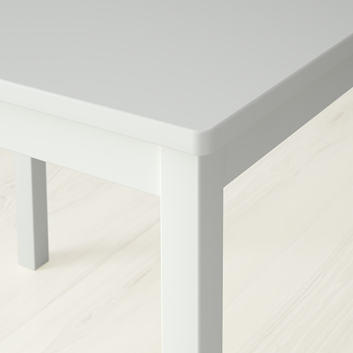 Primer plano de un borde de mesa cuadrado blanco, acabado liso, diseño limpio.